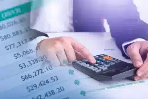 Engineer reviewing technology claim estimates with calculator and spreadsheet