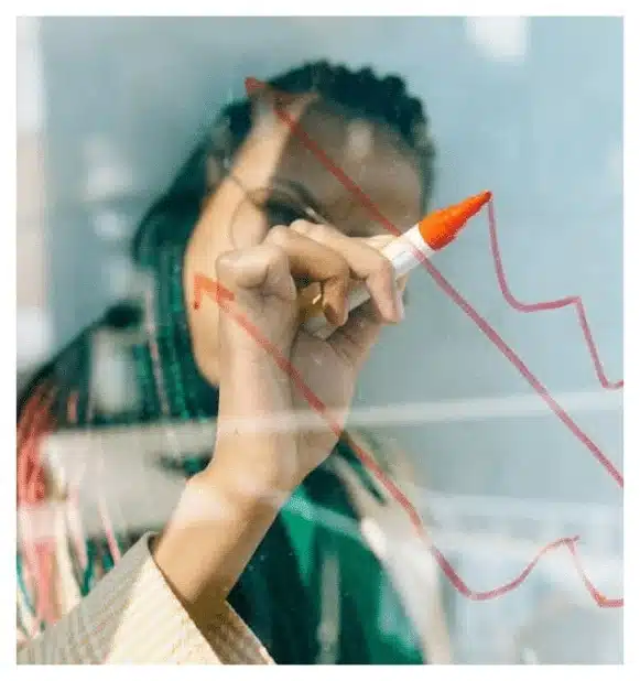 Woman drawing data trends on a transparent board representing disaster pattern analysis